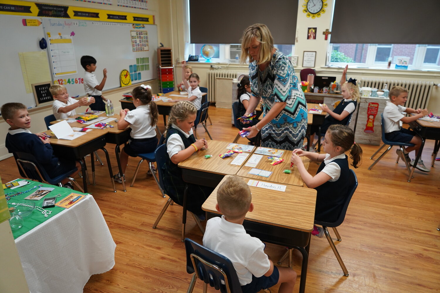 Second-grade teacher Becky Thomas distributes colorful modeling clay to her students on the first day of school at Holy Family School in Hannibal.